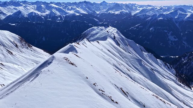 Snow-covered mountain ridge in Serfaus-Fiss-Ladis, Austria, with stunning alpine landscape and distant mountain ranges.