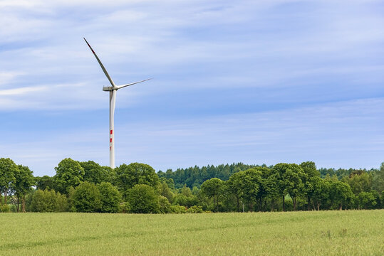 Wind turbine above a green rural landscape with copy space