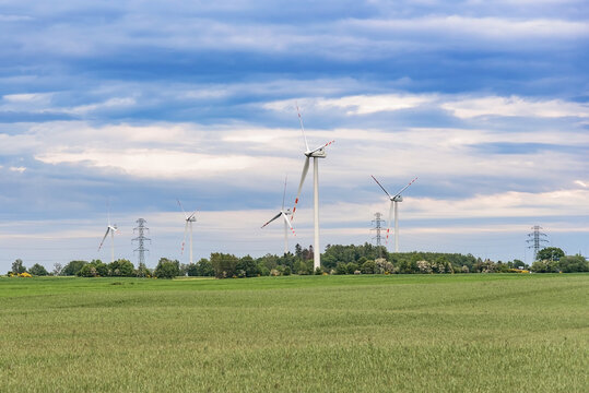 Wind farm and power lines beneath a dramatic cloudy sky