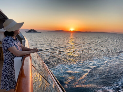 Mature woman looking at sunset from boat on the ocean