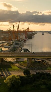 A cinematic shot of the Gdynia mobile port featuring shipping cranes, estakada bridge, and cargo ships at sunset. Perfect for logistics, global trade, and infrastructure documentaries.