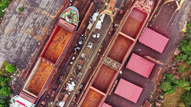The scene shows a shipyard where several ships are being built. There are multiple sections with workers and materials present. The layout is organized, indicating ongoing construction efforts.