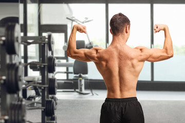 Fototapeta premium Muscular man flexing his back and arm muscles