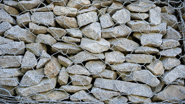 The background with the texture of a stone wall is a gray stone of different sizes in wire.