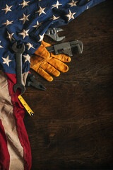 Work glove with tools and American flag on wood background. Symbolic of blue collar workers, USA manufacturing, pride in products Made in United States of America, or Father's day or US Labor Day. © Leigh Prather