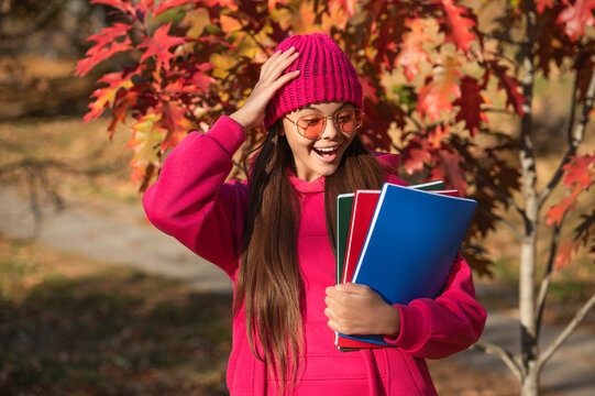 education and knowledge in school of autumn girl holding homework for college outdoor