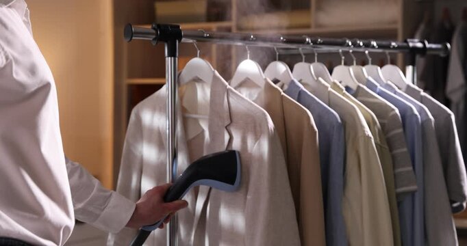 Man steaming jacket with upright steamer at home, closeup