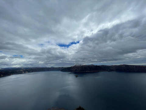 Panoramic View of Lake Mashu Beneath Dramatic Cloudscape in Hokkaido Japan