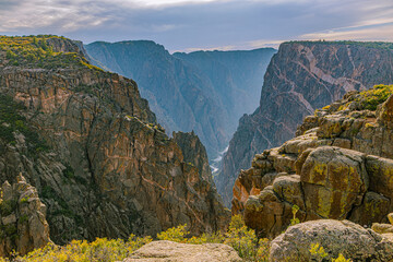 Gunnison River glints far below between massive dark canyon walls with pegmatite Painted Wall streaks, Black Canyon NP, Colorado. © ZL Visuals