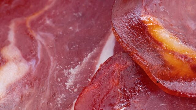 Macro view of sliced basturma meat rotating slowly on wooden surface.