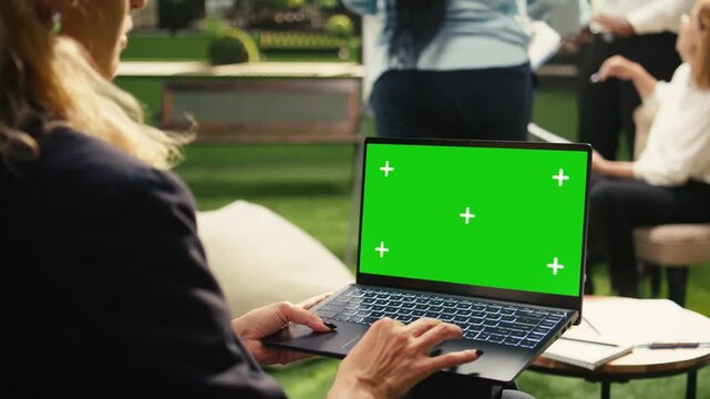 Isolated mockup screen replacement on laptop device with blank screen, businesswoman emphasizing productivity and holding computer with editable screen, outdoor workspace, for screen replacement.