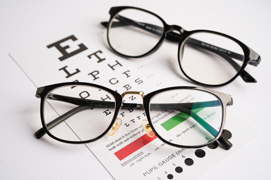 Glasses on eye testing exam chart to check eyesight accuracy of reading.