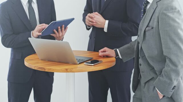 ノートPCを見ながら会話するビジネスパーソン。会議、チームワーク、グループ、ミーティング、人材、会社