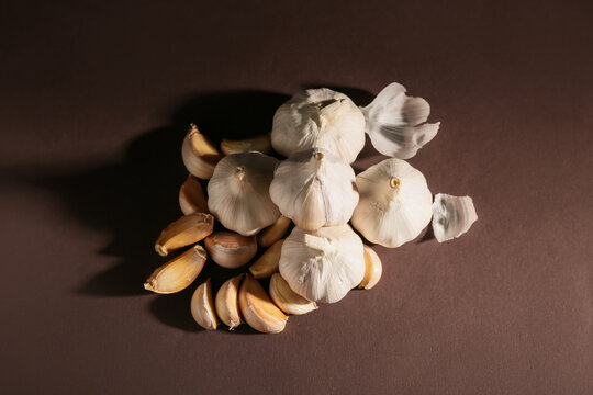 Many fresh garlics on brown background