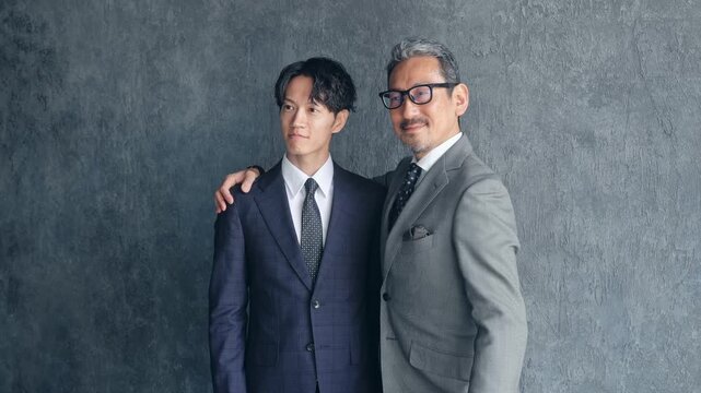 肩を組む男性ビジネスパーソン。チームワーク、団結、経営、人材、事業承継、上司、部下、企業、二人
