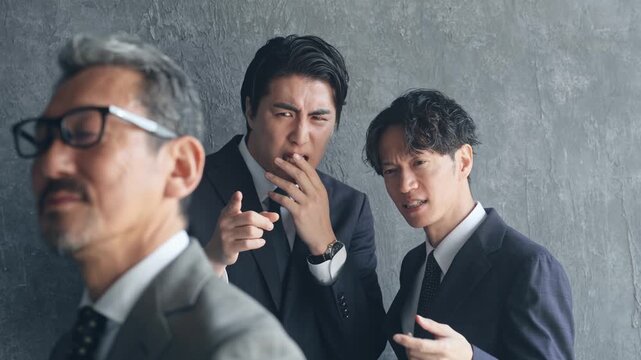 上司を後ろ指さす部下たち。不満、ビジネス、企業、社長、経営者、イライラ、転職、疑問、不正、不祥事
