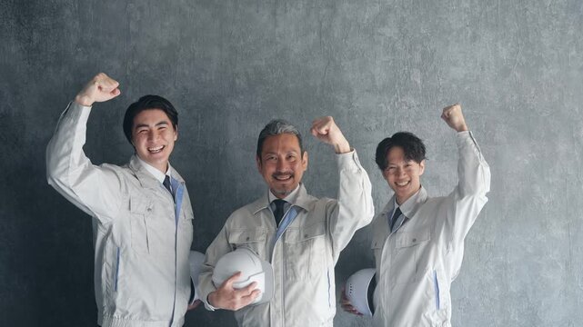 ガッツポーズする男性作業員のグループ。建設、工場、エンジニア、工務店、産業、人材、挑戦、業者、工事