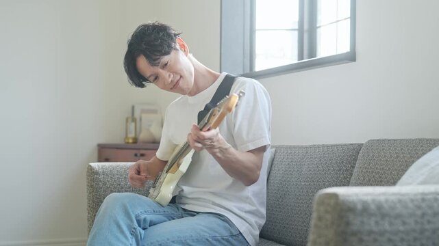 エレキギターを弾く男性。音楽、楽器、演奏、練習、趣味、バンド、音楽家、ミュージシャン、ギタリスト
