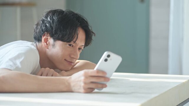 笑顔でスマホを使う男性。アプリ、SNS、動画、ゲーム、リラックス、検索、web、DX、AI、配信