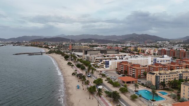 Panoramic high-angle aerial view of Lecheria coastline skyline on a cloudy day.