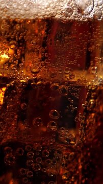 Fizzling cold beverage in the glass. Closeup. Vertical footage