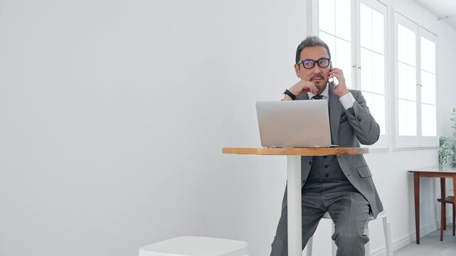 ノートPCを使う男性ビジネスパーソン。パソコン、ビジネス、仕事、DX、スマホ、通話、シニア、ミドル