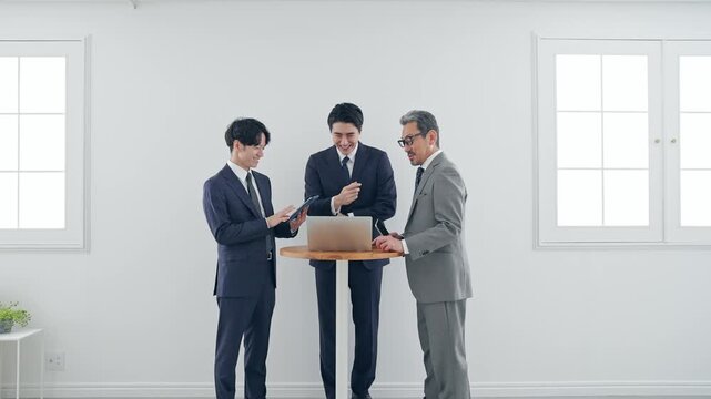 ノートPCを見ながら会話するビジネスパーソン。会議、チームワーク、グループ、ミーティング、人材、会社