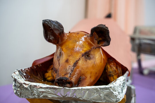 Close up of roasted whole pig head in tray.