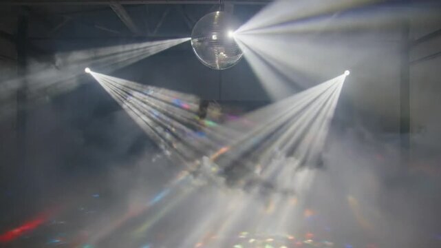 Disco ball stage with bright spotlight beams and fog atmosphere for a party celebration or concert