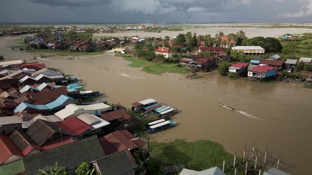 Aerial view of floating village and river with boats in Southeast Asia.