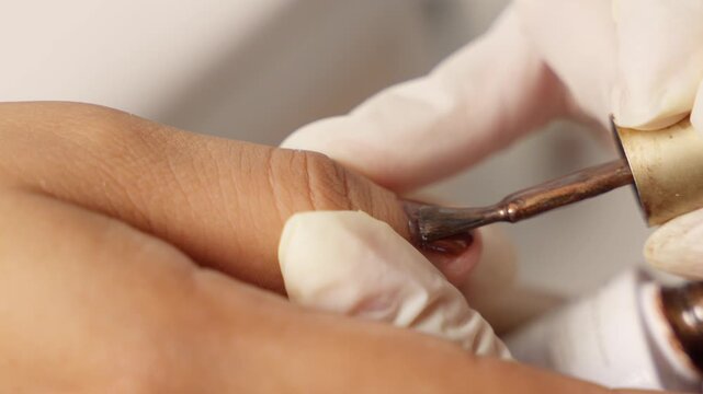 Manicurist applying magnetic cat eye nail polish