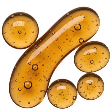 Golden cosmetic serum droplets with bubbles on white background