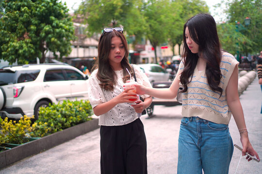Young Female Friends Sharing Cold Drink at Malioboro Yogyakarta Indonesia