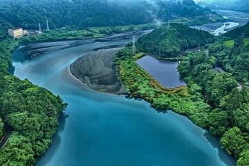 Fototapeta premium Aerial drone photo of reservoir, solar panels and lush forest at sunrise in Shizuoka, Japan