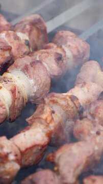 Grilling pork kebab on skewers, cooking process. Vertical footage