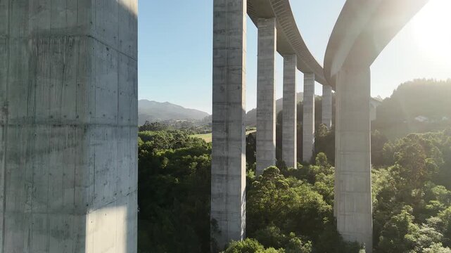 Drone pass between tall concrete pillars of La Concha de Artedo viaduct