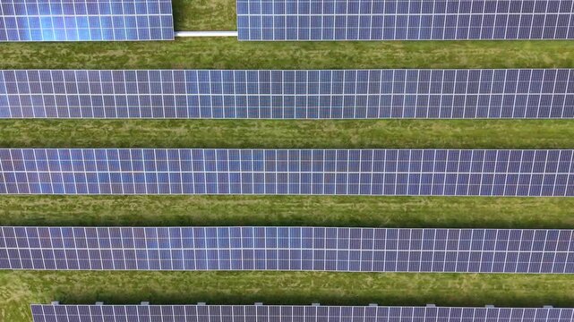 Long row of solar module structure on field. Aerial top-down sideways