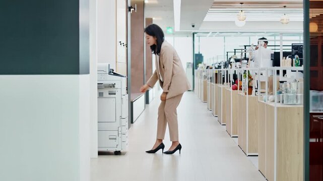 Young Asian Businesswoman Operating Multifunction Office Printer for Document Printing