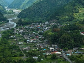 Aerial drone photo of a mountain valley village along a river in Shizuoka, Japan © AeroSkope