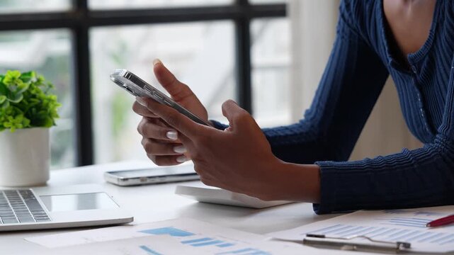 Businesswoman hands using smartphone at office desk