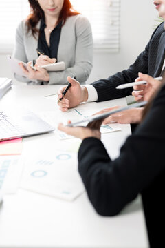 Professional business team discussing financial project in meeting, vertical view.