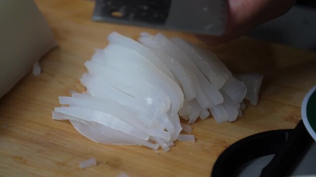 Crop Shot of Vendor's Hand Cutting Bean Jelly on Chopping Board