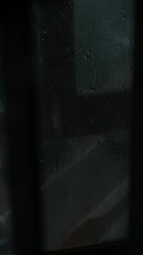 Melancholic Blurred Night Street View Through Rainy Window with Moving Cars and Red Taillights, Lonely Moody Urban City Mood 