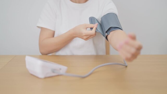 woman checking Blood pressure by Blood pressure monitor with Cuff. Systolic, SYS, Diastolic, DIA, Pulse, Hypertension, Hypotension, Heart rate, Cardiovascular Disease and May World hypertension day