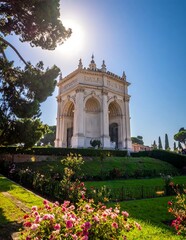 Fototapeta premium Historic white marble monument in a green park under a sunny blue sky in Genoa Italy.