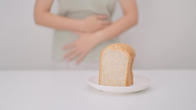 Gluten intolerance, Gluten free and celiac disease or Wheat allergy. woman with wheat bread and having abdominal pain after eat gluten. stomach ache, Nausea, Bloating, Gas, Diarrhea and Skin rash