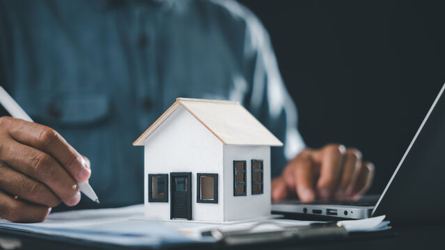 Real estate contract property mortgage finance signing approved, home buying document homeowner house tenant investment insurance involves person signing document near house model, laptop