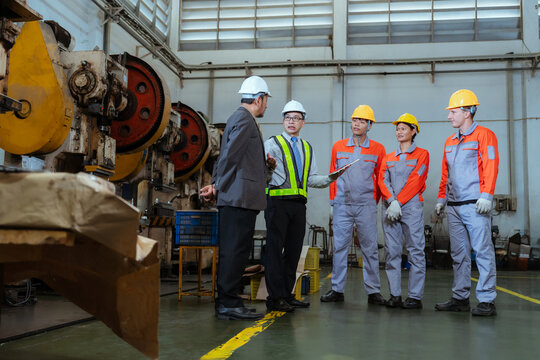 Team discusses safety measures in a factory during a work meeting