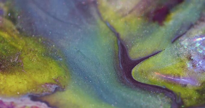 Glitter spill. Ink blend. Purple oil pigment fluid swirling on shimmering color texture with yellow blur flare particles on abstract background.