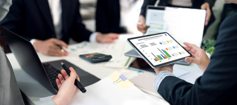Business team analyzing financial growth charts on digital tablet, website banner format.